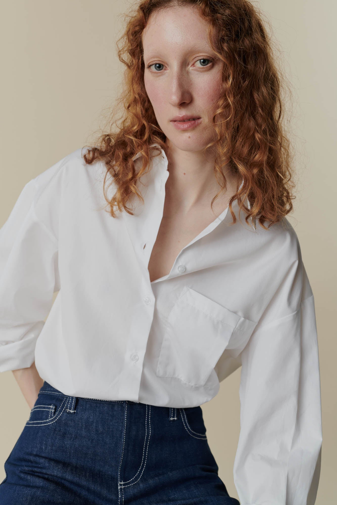 female wearing the white esme long sleeve shirt and some community clothing high waisted jeans