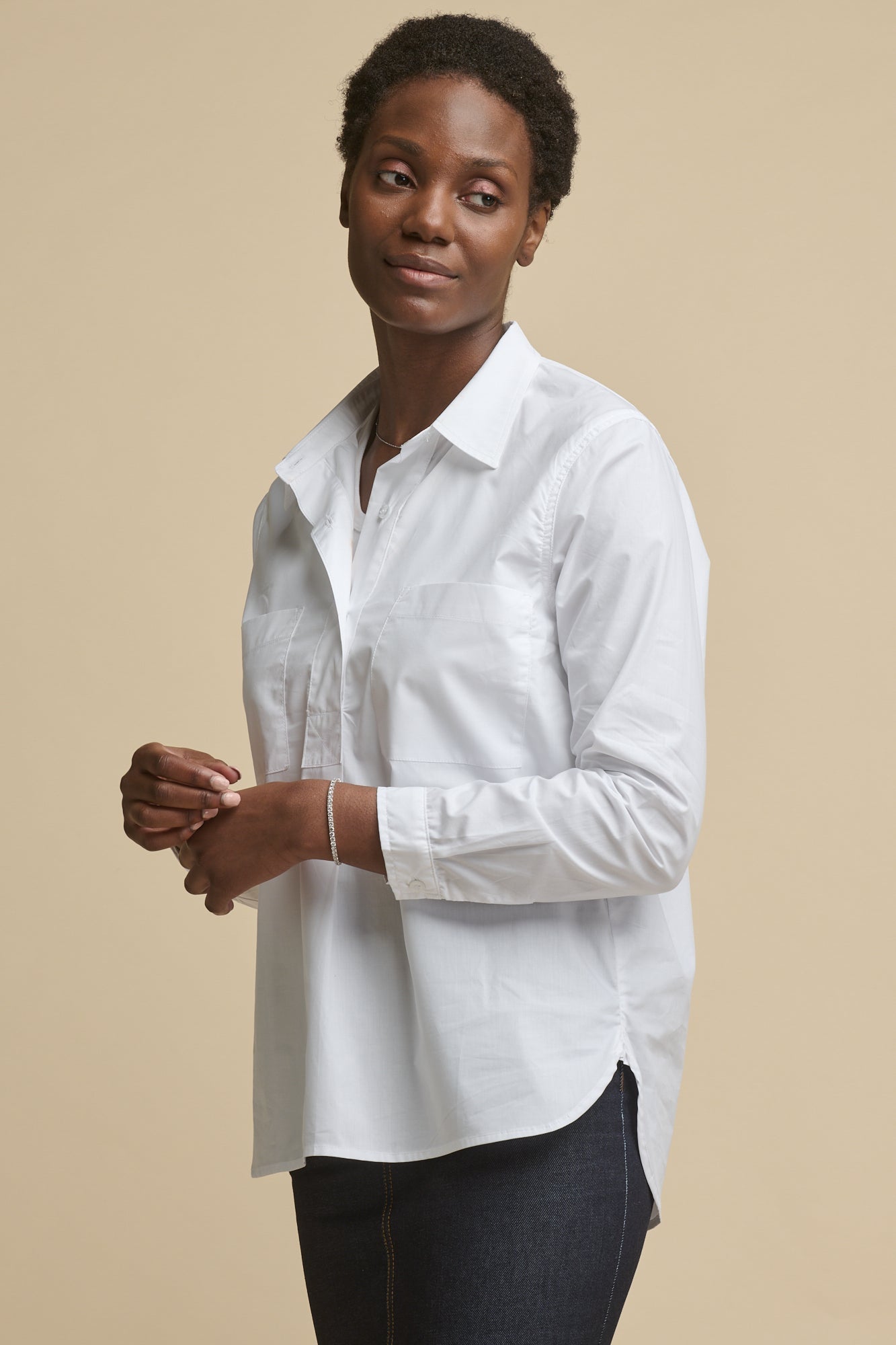 Thigh up image of female wearing Olivia half placket lightweight cotton shirt in white paired worn over racer back vest in white